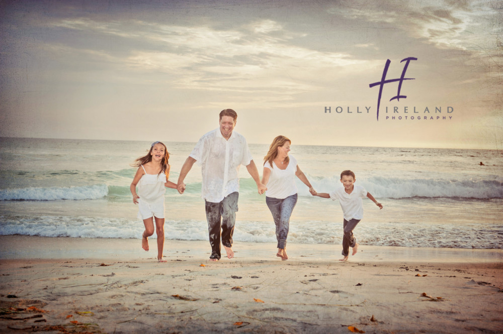 Fun running family at a beach photo shoot in Carlsbad