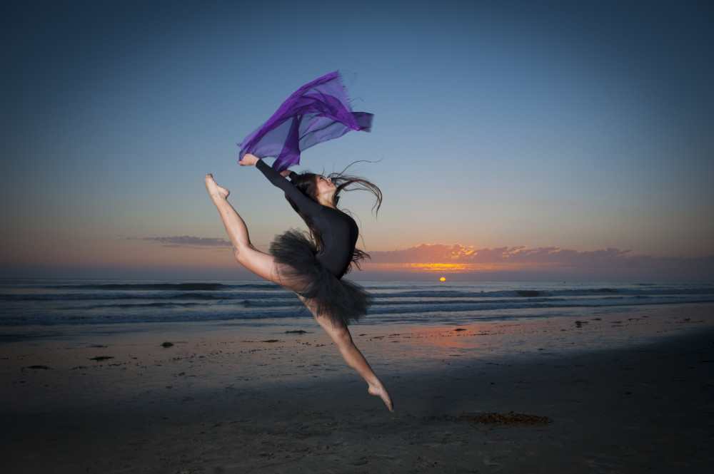 Jumping dancer at the beach at sunset CA