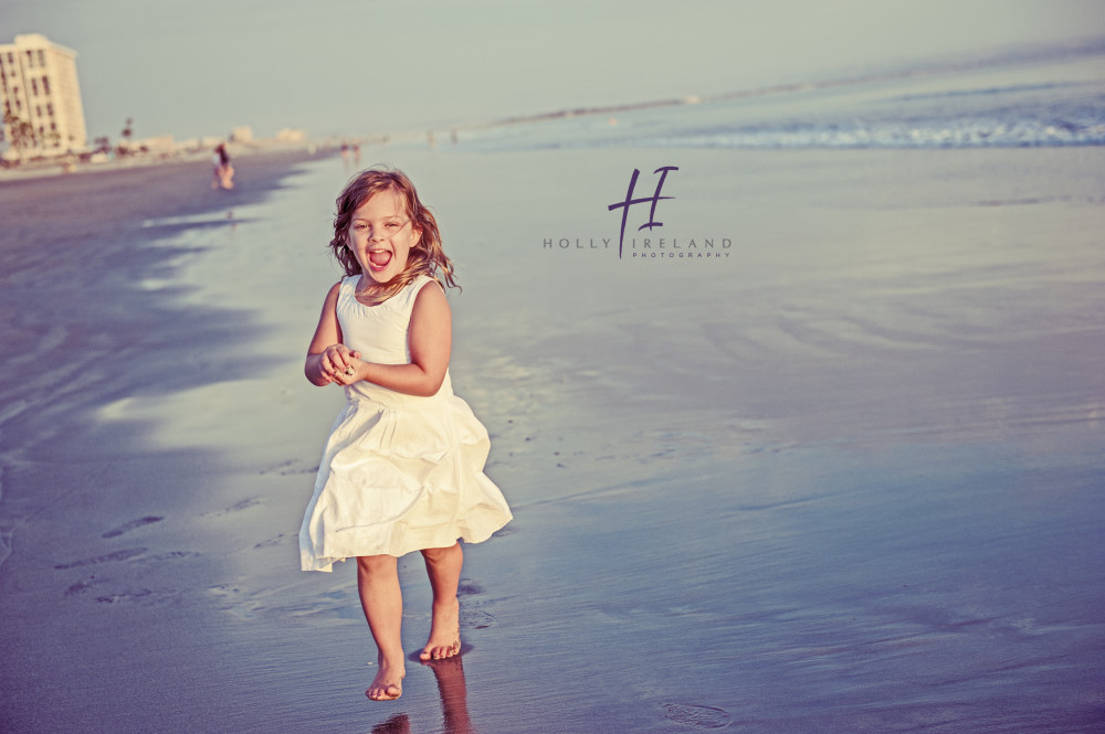 Beautiful little girl running on the beach in San Diego CA