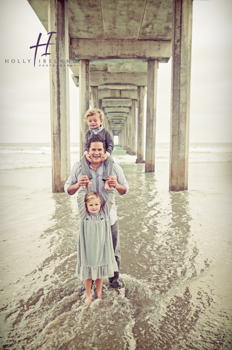 father and kids photo under a pier in san diego